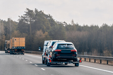 Luxury vehicle covered and hauled on road