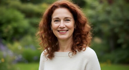 Portrait of a smiling woman with auburn hair outdoors in natural light