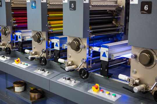 Detailed view of flexographic multi-color industrial printing press rollers. Modern packaging and printing technology.