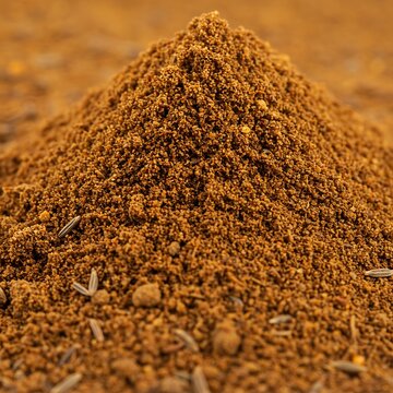 Aromatic spice composition: Close-up of ground cumin with scattered seeds in detail arrangement