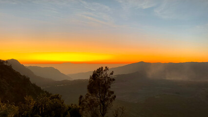 View of magnificent Mount Bromo, Mount Batok, and its giant caldera with sea of sand, with sunrise sky in the early morning. Located in Bromo Tengger Semeru National Park, East Java, Indonesia.