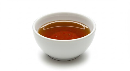 A small white bowl filled with amber colored liquid on a white background.