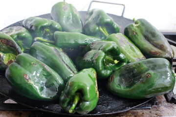 Poplano peppers are roasted in a pan