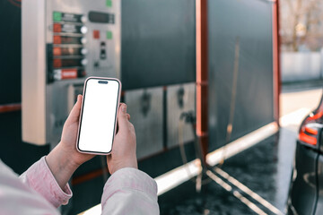 Person using a smartphone at a car wash