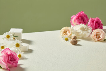 Still life photo with shea butter, pink and cream roses on soft beige background. Clean natural ingredient composition with open space for cosmetic product design.