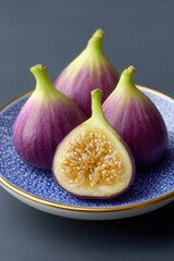 Obraz premium Delicious baked figs arranged artfully on a decorative blue plate in a cozy kitchen setting. National Fig Week