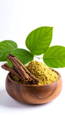 Wooden bowl of powder with cinnamon sticks and leaves