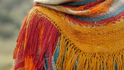 A woman wrapped in a colorful shawl stands in front of a majestic mountain, offering a serene and peaceful scene