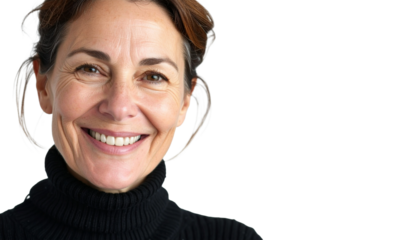 Close-up of an attractive middle aged woman with toothy smile wearing black turtleneck sweater while staning.