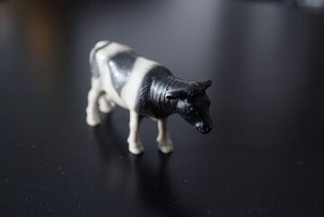 A miniature figure of a domestic black and white cow that irresistibly reminds of the village and childhood and the taste of fresh domestic milk
