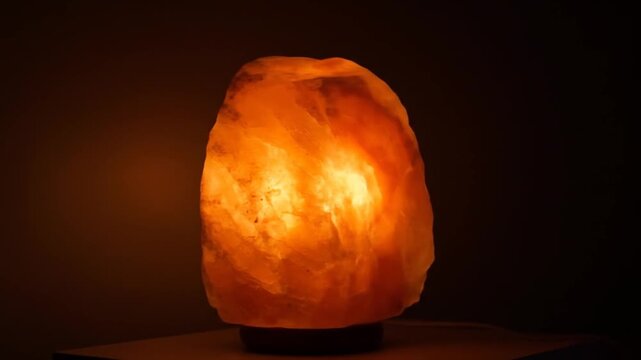 Illuminated Himalayan Salt Lamp Glows Warmly in Darkness.