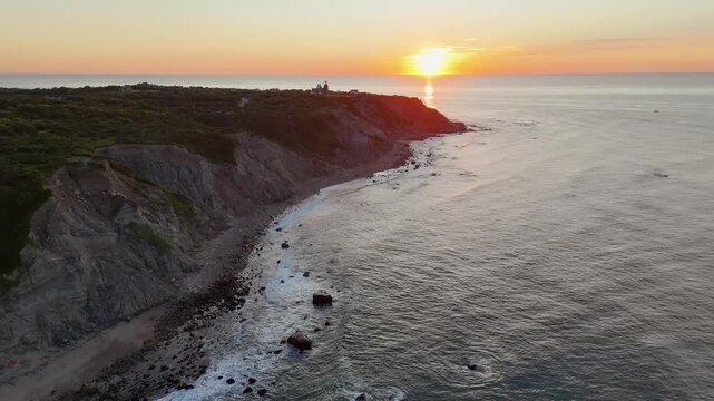 Aerial view of the dramatic Mohegan Bluffs where the lighthouse stands guard, with the sun reflecting off the ocean, New Shoreham, Rhode Island, United States.