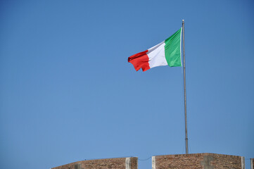 Waving flag of Italy against blue sky