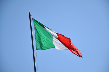 Waving flag of Italy against blue sky