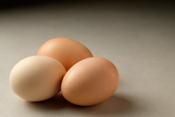 Three eggs resting peacefully on a smooth surface in soft light
