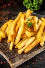 Golden French fries on rustic board