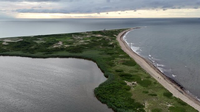 Aerial view of a sandy beach juxtaposed with lush green vegetation creating a stunning contrast against the vast expanse of the ocean, New Shoreham, Rhode Island, United States.