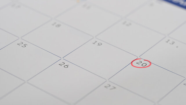 Close up of a calendar page with the 20th day circled in red, representing an important appointment