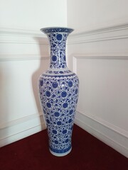 A big ceramic vase in the corner of a room
