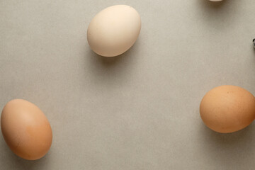 Natural brown and white eggs arranged on a neutral surface in soft lighting