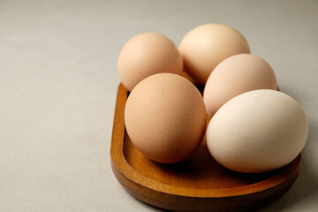 Freshly collected eggs displayed on a wooden tray in a cozy kitchen setting