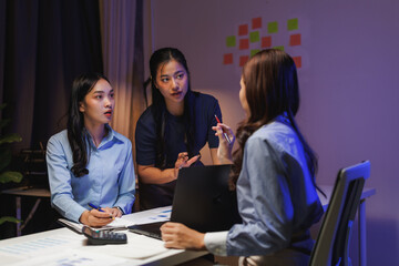 Businesswomen working late in office meeting discussing strategy