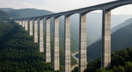 Massive concrete viaduct bridge spanning a deep mountain valley.