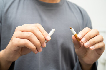Quit smoking, Asian teenage man breaking destroy cigarette in hand.
