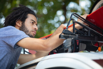 man fixing a car roof rack outdoors