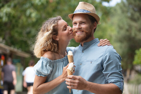 romantic couple eating ice cream at park