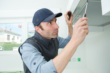 handyman removing filter from a exhaust hood
