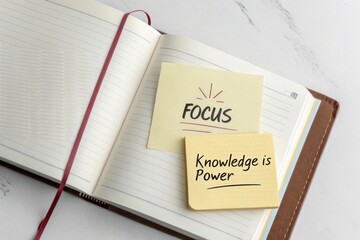 Open book with focus labeled sticky notes on a desk