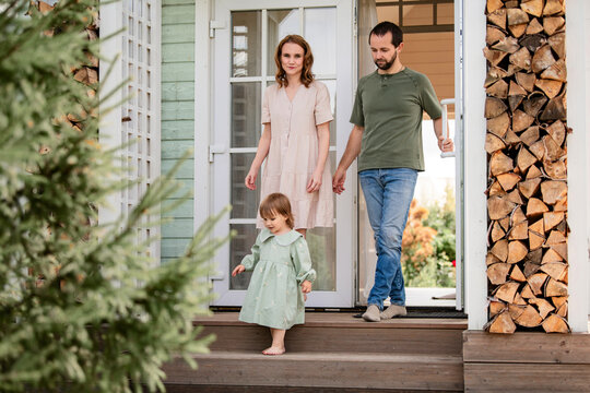 Man and woman with child leaving house.