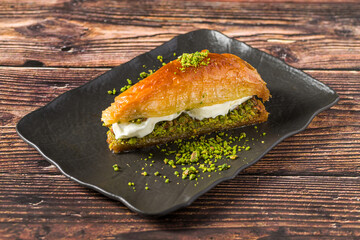 Traditional Turkish pistachio baklava slice served on black plate
