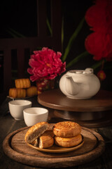 Traditional Chinese Mid-Autumn Festival mooncakes on a wooden table, dark tone.