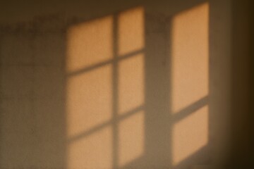 Warm sunlight casting window shadows on wall, cozy lifestyle and minimal design concept symbolizing peace and relaxation.