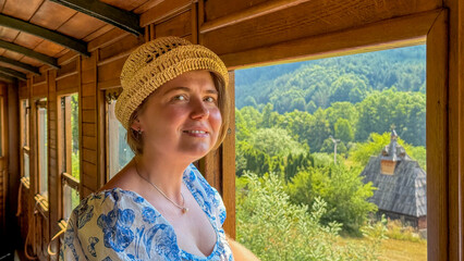 A smiling Caucasian woman in a sun hat journeys through verdant hills on a vintage train, evoking...
