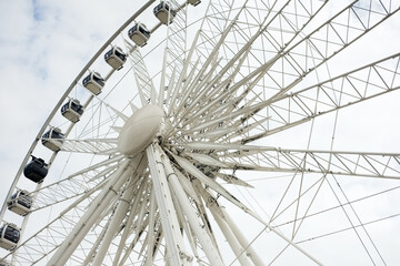 Stunning modern Ferris wheel structure against a bright sky, offering panoramic views and iconic city landmark appeal for tourism.