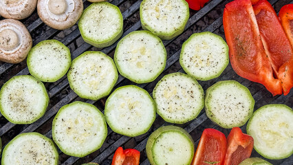 Grilled zucchini rounds and bell peppers dance on charcoal, evoking Mediterranean enchantment and...