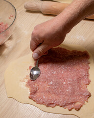 Crafting delicate ravioli meat filling with European male hands, invoking Saint Lucy's Day warmth and culinary nostalgia April 5 2025, Barcelona, Spain