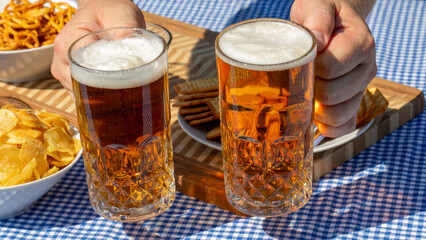 Two frosty mugs of amber beer clink gleefully over salty pretzels and crisp snacks, embodying Oktoberfest's joyful camaraderie April 5 2025, Barcelona, Spain