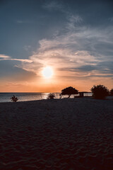 Floating in the waves at sunset, sun just above horizon, going down, orange sky, tranquil sea. Peaceful moment, vacations, summer mood. Dominican Republic. Horizontal video.