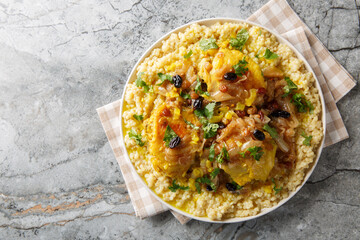 Traditional Moroccan couscous Chicken Tfaya With Caramelized Onion and Raisins closeup on the plate on the table. Horizontal top view from above