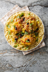 Savory sweet fragrant chicken couscous tfaya is a comforting and special meal closeup on the plate on the table. Vertical top view from above