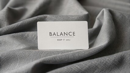 White card with Balance text resting on textured gray fabric
