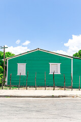 Pedernales, Dominican Republic, 8 august 2025. Typical Dominican Caribbean house made of wood, painted a bright green color.
