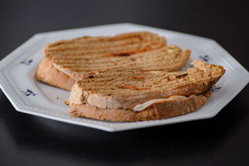 Sandwiches made of homemade bread toasted with ham, spreadable cheese and ketchup inside. Homemade food that is always good to start or end the day.