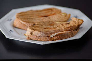 Sandwiches made of homemade bread toasted with ham, spreadable cheese and ketchup inside. Homemade food that is always good to start or end the day.