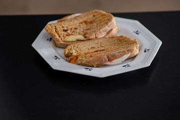 Sandwiches made of homemade bread toasted with ham, spreadable cheese and ketchup inside. Homemade food that is always good to start or end the day.