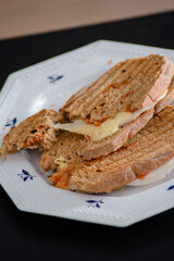 Sandwiches made of homemade bread toasted with ham, spreadable cheese and ketchup inside. Homemade food that is always good to start or end the day.